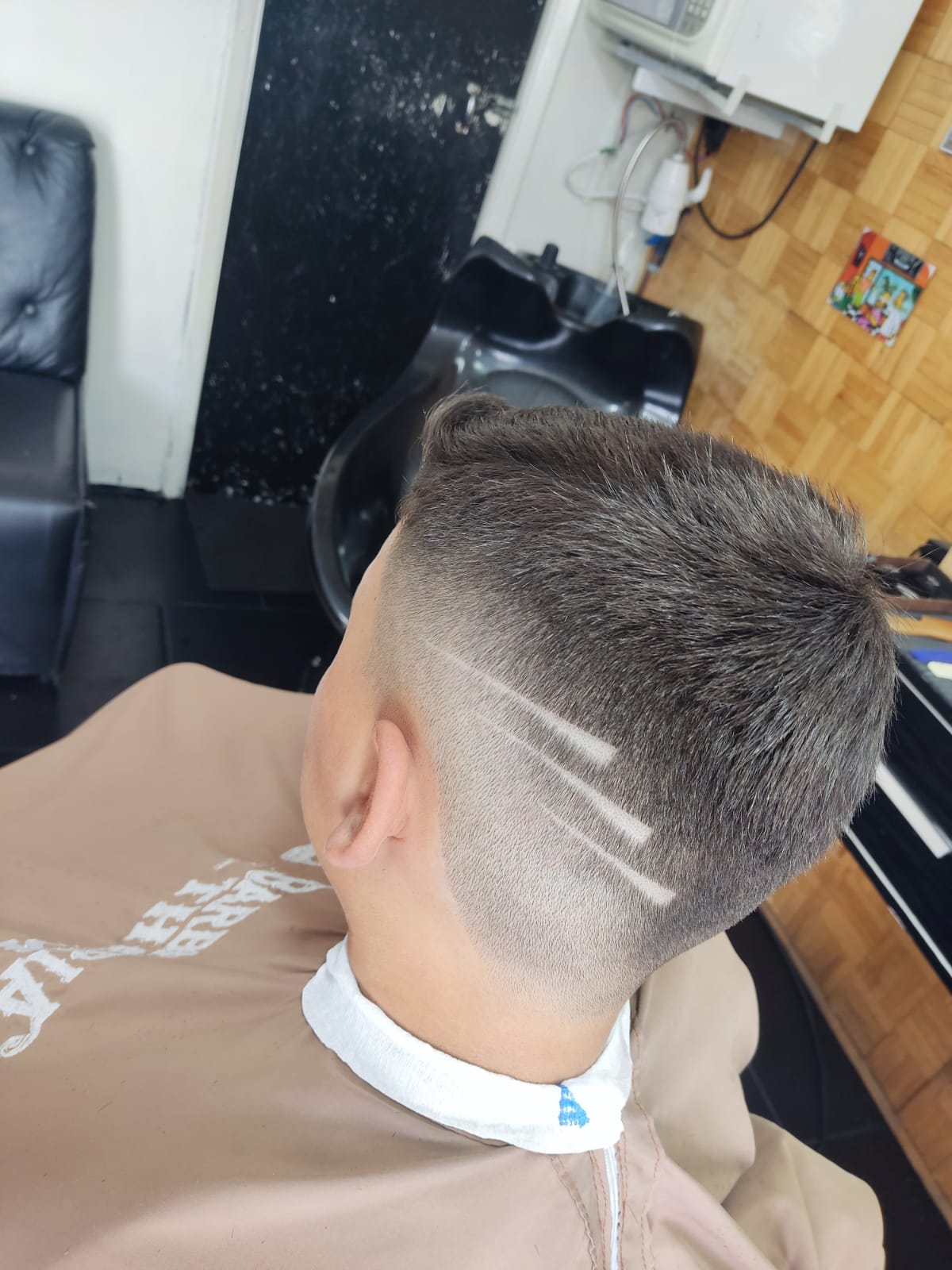 Corte com risco desenhado na nuca de um cliente da Barbearia Thom