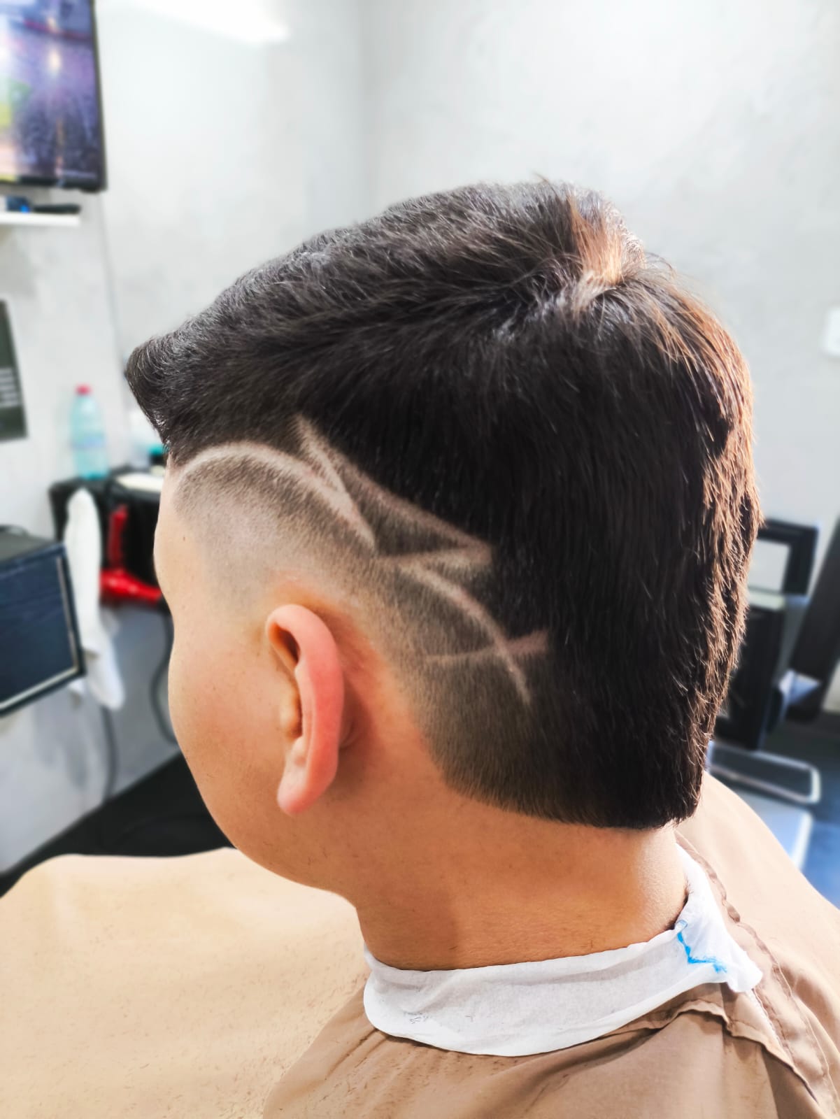 Corte com desenho na lateral da cabeça de um cliente da Barbearia Thom